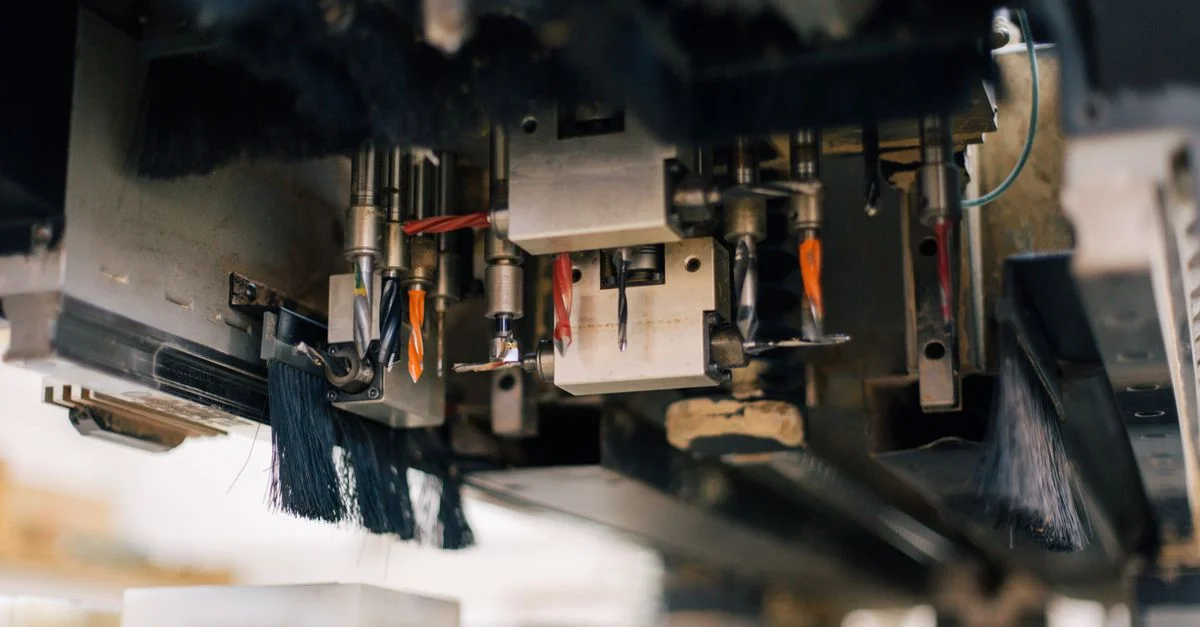 Vue détaillée d'une machine industrielle avec plusieurs perceuses et brosses dans un environnement d'usine.