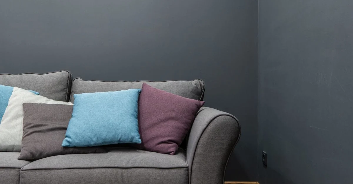 Un canapé gris élégant avec des coussins vibrants dans un cadre de salon moderne.