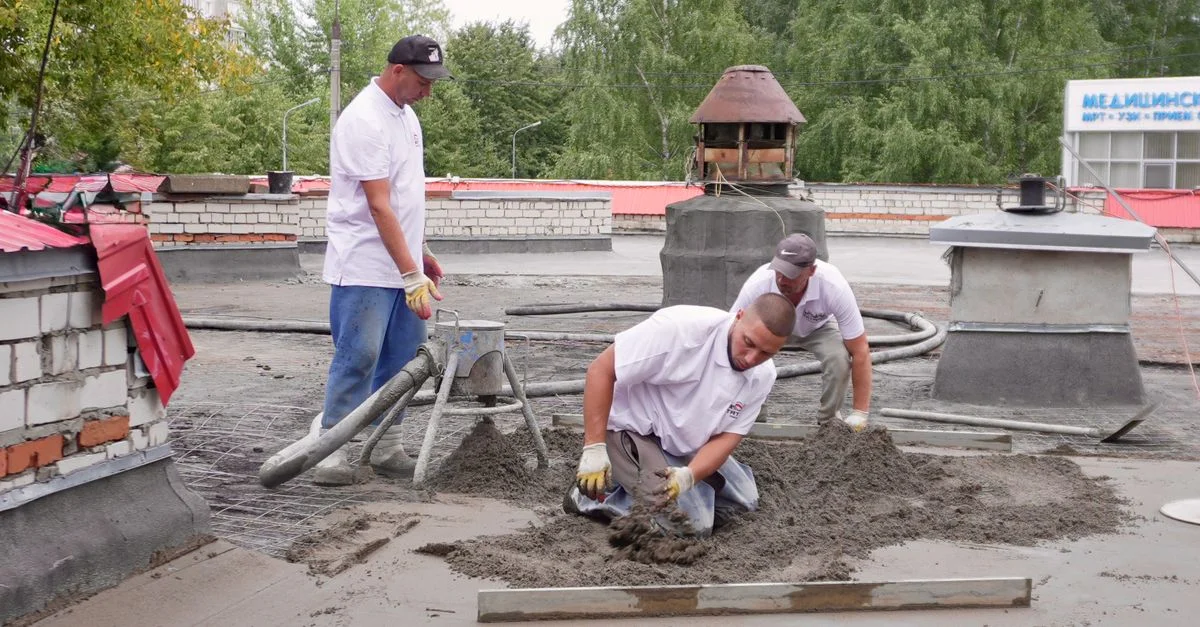 Une équipe d'ouvriers du bâtiment coule du béton sur un toit, illustrant parfaitement le travail d'équipe.