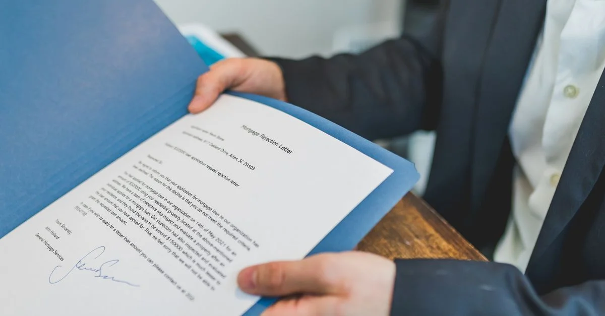 Gros plan sur un contrat immobilier examiné par un agent et un client.