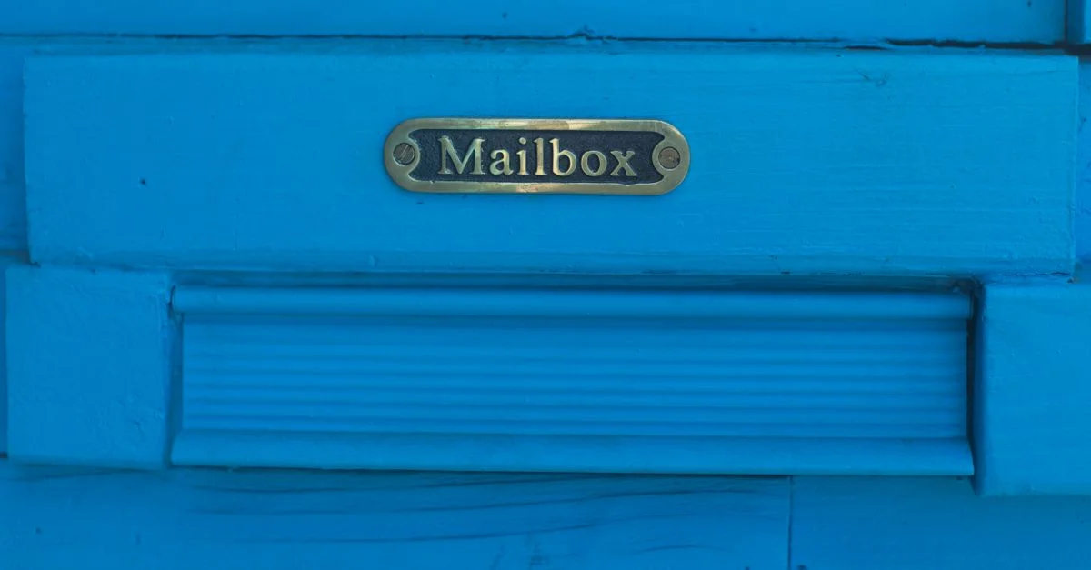 Gros plan sur une boîte aux lettres bleue vibrante avec des accents métalliques décoratifs.