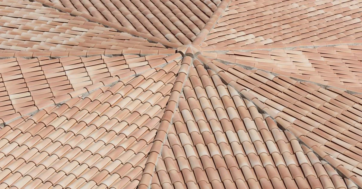 Vue détaillée, vue de dessus, de tuiles de toit en terre cuite formant un motif géométrique.