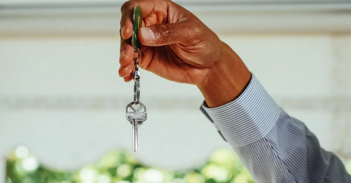 Une main tenant un jeu de clés de maison, symbolisant l'achat ou la location d'un nouveau logement.